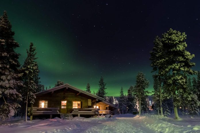 Northern Lights over a cabin in Lapland