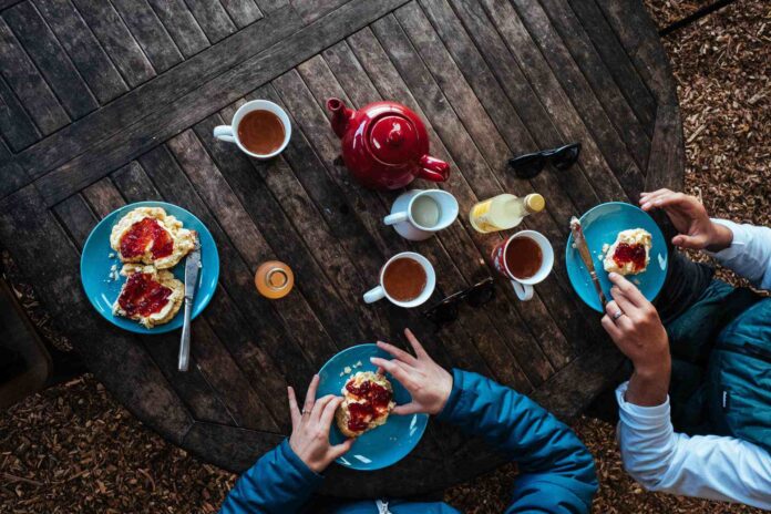 Visitors enjoying scones and jam on a picnic table